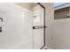 Modern shower featuring glass doors and a black frame, with a window for natural light at 1361 N Claiborne --, Mesa, AZ 85205