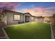 Spacious backyard with artificial turf, covered patio, and pergola at 14634 W Wethersfield Rd, Surprise, AZ 85379