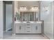 Contemporary bathroom with a double vanity, stylish mirrors, and a walk-in glass shower at 14634 W Wethersfield Rd, Surprise, AZ 85379