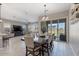 Elegant dining area with a large table and chairs, seamlessly connected to the kitchen and living area at 14634 W Wethersfield Rd, Surprise, AZ 85379