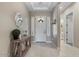 Inviting foyer with tiled floor, console table, and decorative mirror, creating a welcoming entrance at 14634 W Wethersfield Rd, Surprise, AZ 85379