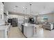 Open-concept kitchen with large island, stainless steel appliances, and modern white cabinets, perfect for entertaining at 14634 W Wethersfield Rd, Surprise, AZ 85379