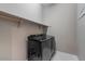 Modern laundry room featuring gray washer and dryer and upper shelving at 14634 W Wethersfield Rd, Surprise, AZ 85379