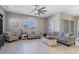Bright living room with a ceiling fan, tile floors, stylish furniture and a sunlit window at 14634 W Wethersfield Rd, Surprise, AZ 85379