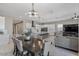 Open-concept living space with dining table, kitchen island, and comfortable seating, perfect for modern living at 14634 W Wethersfield Rd, Surprise, AZ 85379