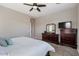 Well-lit main bedroom with a king bed, dark wood furniture, and comfortable carpet at 14634 W Wethersfield Rd, Surprise, AZ 85379