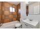 Tiled bathroom featuring a sink with storage, commode, and a tub shower with a window at 1529 E Edgemont Ave, Phoenix, AZ 85006