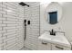 Modern bathroom with black fixtures, walk-in shower with subway tiles, and round mirror above the vanity at 1529 E Edgemont Ave, Phoenix, AZ 85006