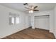 Bright bedroom with laminate flooring, ceiling fan and light fixture, window with blinds, and large closet at 1529 E Edgemont Ave, Phoenix, AZ 85006
