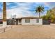 Exterior view showcasing the home's white facade, desert landscaping, and secure gated entry at 1529 E Edgemont Ave, Phoenix, AZ 85006