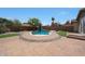 Inviting backyard oasis showcasing a pool, brick patio, manicured landscaping, and cozy spots for outdoor relaxation at 15365 W Valentine St, Surprise, AZ 85379