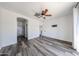 Neutral bedroom with wood-style flooring, ceiling fan, walk-in closet, and an ensuite bathroom at 15365 W Valentine St, Surprise, AZ 85379
