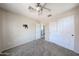Spacious bedroom featuring plush carpet, a ceiling fan, and convenient closet access at 15365 W Valentine St, Surprise, AZ 85379
