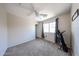 Inviting bedroom with a ceiling fan, plush carpet, and a personal treadmill for fitness at 15365 W Valentine St, Surprise, AZ 85379