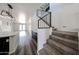 Hallway featuring hardwood floors, white walls, and view of staircase with carpet and iron railings at 15365 W Valentine St, Surprise, AZ 85379