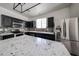 Modern kitchen features stainless steel appliances, gray backsplash, and a large center island with granite countertops at 15365 W Valentine St, Surprise, AZ 85379