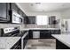 Modern kitchen featuring black cabinetry, stainless steel appliances, and quartz countertops at 15365 W Valentine St, Surprise, AZ 85379