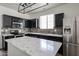 Modern kitchen featuring black cabinetry, stainless steel appliances, and quartz countertops at 15365 W Valentine St, Surprise, AZ 85379