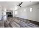 Spacious open-concept living area with dark vinyl floors, ceiling fan, and plenty of natural light at 15365 W Valentine St, Surprise, AZ 85379