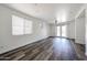 Bright living room with wood-style floors, ceiling fan, and a sliding glass door leading to the backyard at 15365 W Valentine St, Surprise, AZ 85379