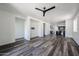 Open floor plan living area with stylish flooring and a ceiling fan fixture with connections for a wall mounted television at 15365 W Valentine St, Surprise, AZ 85379