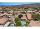 An aerial view of beautiful homes with private pools, landscaping, solar panels and mountain views in a golf community at 15829 S 13Th Pl, Phoenix, AZ 85048