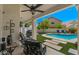 View of the backyard with an in ground pool, green grass, rock landscaping and covered patio at 15829 S 13Th Pl, Phoenix, AZ 85048