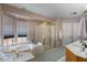 Well-lit bathroom featuring a soaking tub under the window and a glass shower with gold trim at 15829 S 13Th Pl, Phoenix, AZ 85048