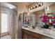 Bathroom featuring dual sinks, floral arrangement, vanity lighting, and shower at 15829 S 13Th Pl, Phoenix, AZ 85048