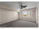 Bedroom has neutral walls, carpeted floor, a ceiling fan, and a window overlooking the neighborhood at 15829 S 13Th Pl, Phoenix, AZ 85048