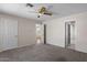Bedroom with a ceiling fan, carpet, and white trim, with a view to the landing and another bedroom at 15829 S 13Th Pl, Phoenix, AZ 85048