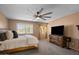 Spacious bedroom with neutral paint, a ceiling fan, and a decorative side window at 15829 S 13Th Pl, Phoenix, AZ 85048