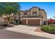 Charming two-story home featuring a two-car garage, desert landscaping, and a beautiful tree in the front yard at 15829 S 13Th Pl, Phoenix, AZ 85048
