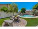 Beautiful backyard with a cozy fire pit, lounge chairs, lush landscaping, and a sparkling pool at 15829 S 13Th Pl, Phoenix, AZ 85048