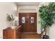Elegant foyer featuring a wooden double door, beautiful sidelights and transom, decorative glass, and a hardwood floor at 15829 S 13Th Pl, Phoenix, AZ 85048