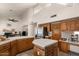 Spacious kitchen featuring an island, wooden cabinetry, stainless steel refrigerator and a view of the living room at 15829 S 13Th Pl, Phoenix, AZ 85048