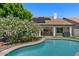 Inviting backyard pool with lush landscaping, covered patio, and solar panels on the roof of the single story home at 15829 S 13Th Pl, Phoenix, AZ 85048