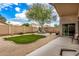 Landscaped backyard with mature tree, gravel, turf and stone at 16055 S 18Th Dr, Phoenix, AZ 85045