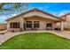 Home's backyard features artificial grass, covered patio, and desert landscaping at 16055 S 18Th Dr, Phoenix, AZ 85045