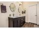 Bathroom features double sink vanity with quartz countertops, wood-look tile flooring and modern fixtures at 16055 S 18Th Dr, Phoenix, AZ 85045