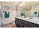 Bathroom with a vanity featuring dual sinks and wainscoting at 16055 S 18Th Dr, Phoenix, AZ 85045
