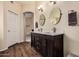 Bathroom features double sink vanity with quartz countertops, wood-look tile flooring and modern fixtures at 16055 S 18Th Dr, Phoenix, AZ 85045
