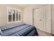 Bright bedroom with carpet and a blue striped quilt, adjacent to a white closet at 16055 S 18Th Dr, Phoenix, AZ 85045