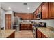 Well-equipped kitchen with stainless steel appliances, granite countertops, and rich wood cabinetry at 16055 S 18Th Dr, Phoenix, AZ 85045
