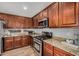 Well-equipped kitchen featuring stainless steel appliances, granite countertops, and wood cabinets at 16055 S 18Th Dr, Phoenix, AZ 85045