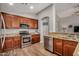 Open kitchen with stainless steel appliances, granite countertops, and warm wood cabinets at 16055 S 18Th Dr, Phoenix, AZ 85045