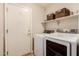 Functional laundry room with modern washer, dryer, and ample shelving for storage at 16055 S 18Th Dr, Phoenix, AZ 85045