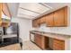 Functional kitchen featuring wood cabinets, tile floors, and modern appliances for a convenient and efficient cooking experience at 16602 N 25Th St # 223, Phoenix, AZ 85032