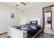 Bright bedroom with a white bed frame, ceiling fan, and doorway to another room at 17030 N 57Th St, Scottsdale, AZ 85254