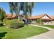 Inviting single-story home with a red tile roof, lush green lawn, mature trees, and neatly trimmed landscaping at 17030 N 57Th St, Scottsdale, AZ 85254